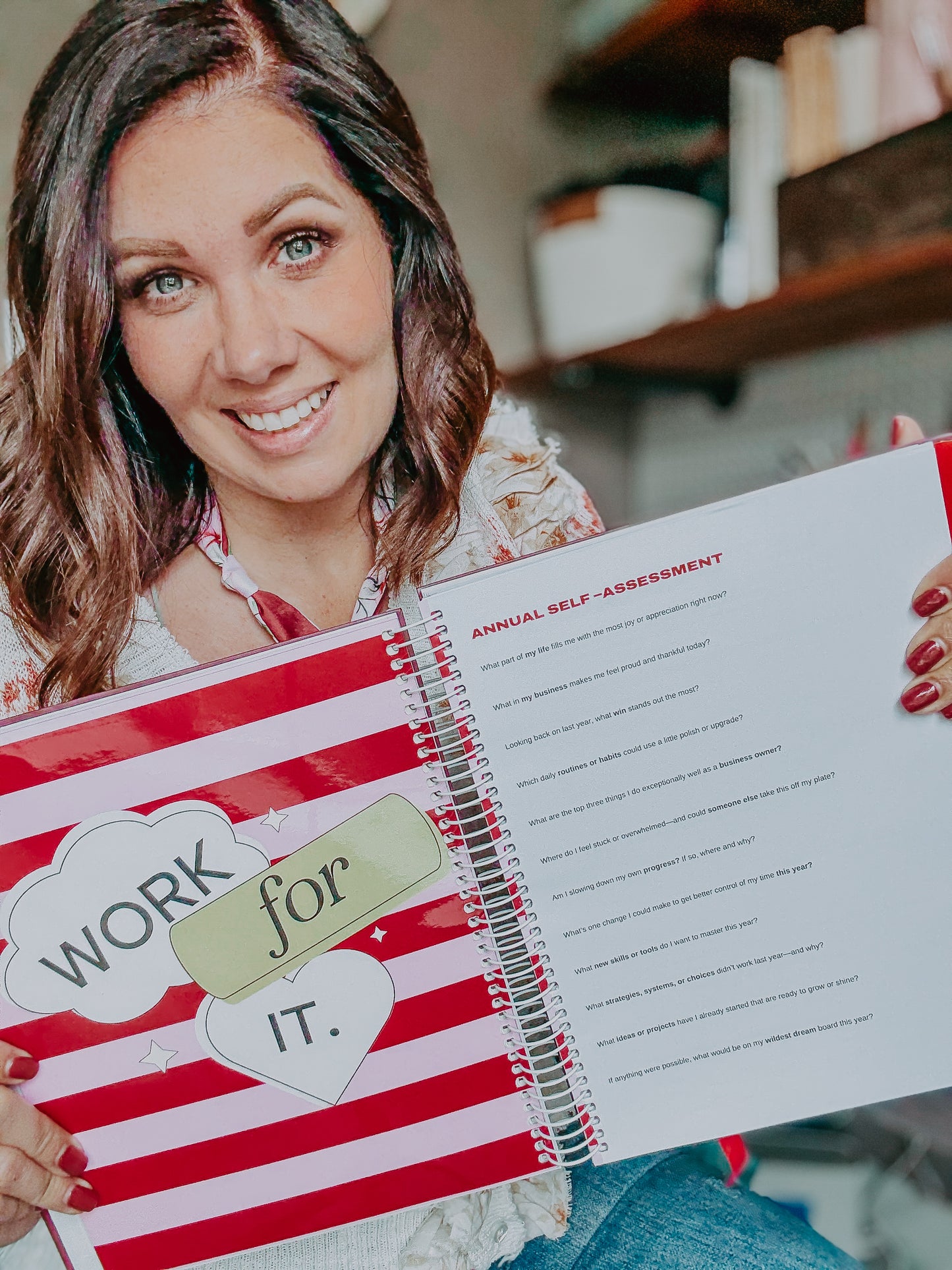 Person holding a notebook with 'Work for it.' text and a self-assessment form.