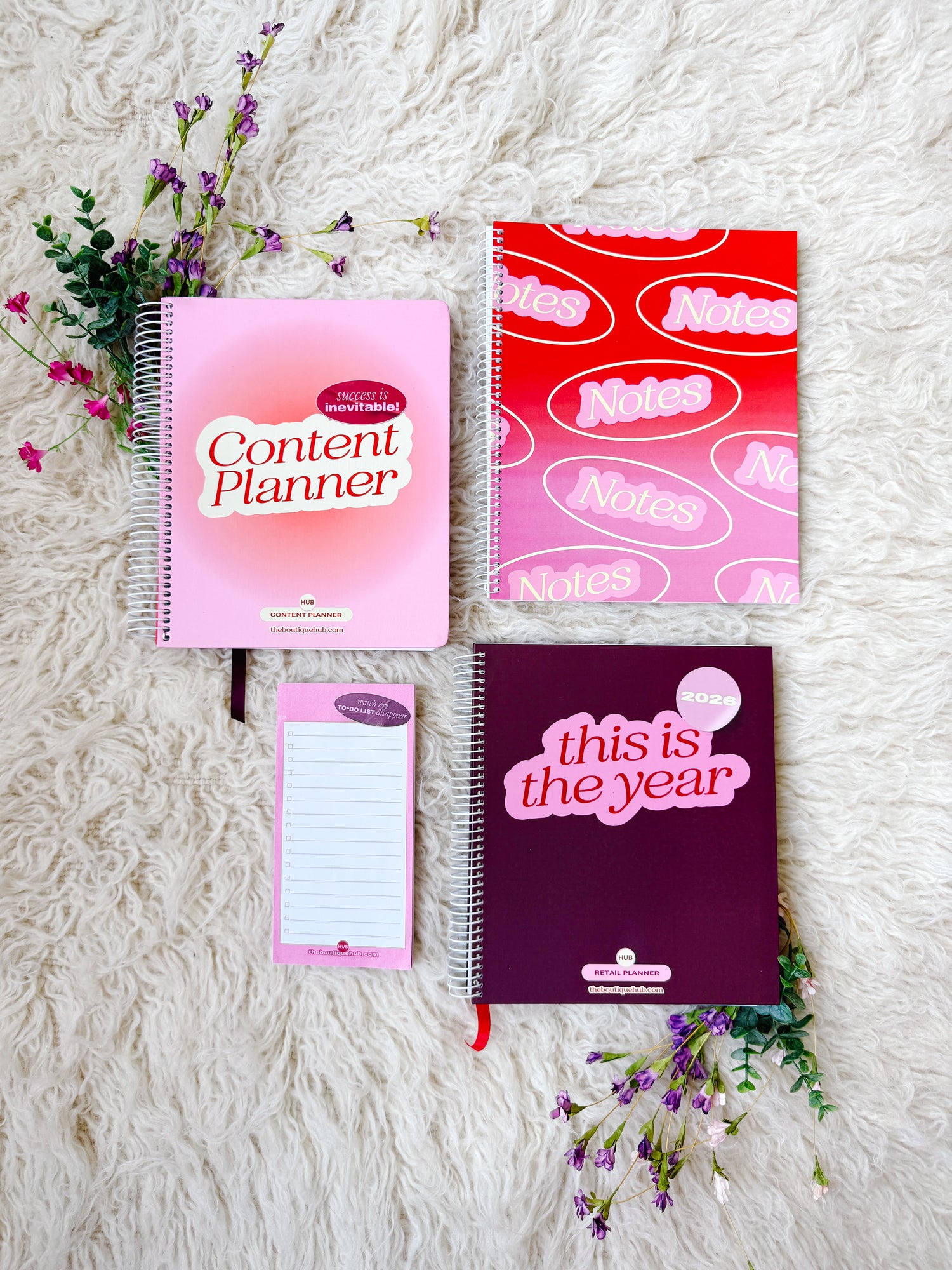 Set of planners and notebooks with colorful designs on a textured surface.